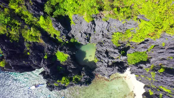 Queue of Tourists Ccomes in Hidden Tropical Lagoon Surrounded by Cliffs in Miniloc island