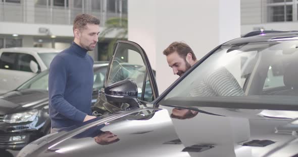 Male Caucasian Car Dealer Opening Car Door, Adult Man Sitting Into Salon