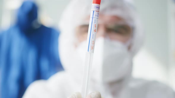 PCR Test in Laboratory Doctor Looking at COVID19 Swab Collection Kit Lab Worker Wearing PPE Medical