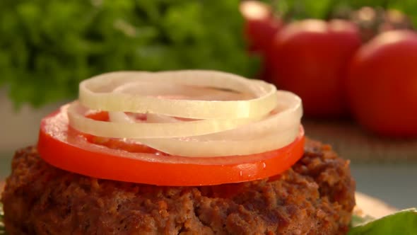 Rings of Chopped Onions Falls on a Hamburger