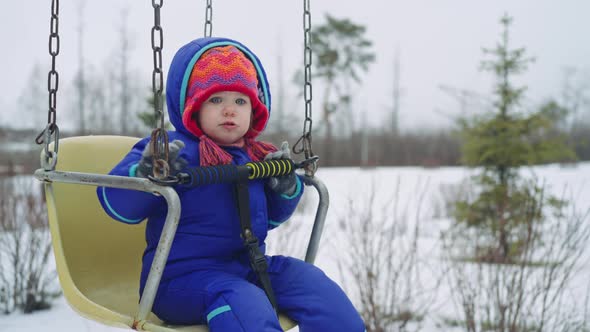 Little Girl Swinging in the Playground