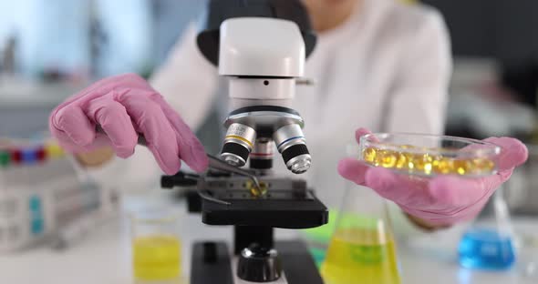 Scientist Chemist Examining Medical Capsules of Omega3 Amino Acids Under Microscope  Movie