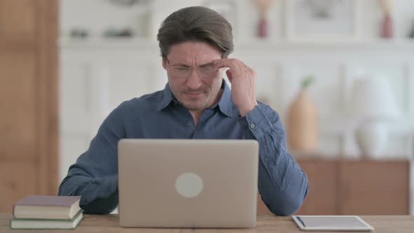 Man having Headache while Working on Laptop