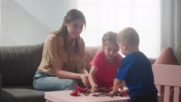 Young Mother with Children Rejoice in Broken Piggy Bank