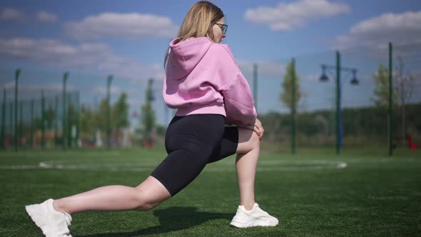 Side View Positive Plussize Woman Doing Lunges Gesturing Thumb Up Looking at Camera Smiling