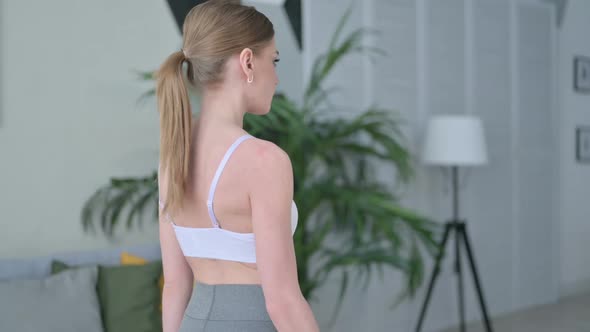 Back View of Young Woman Doing Workout with Dumbbells at Home