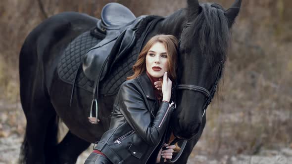 Beautiful Young Woman Stroking a Horse and Posing Outdoors