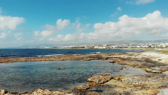 Drone Shot of Wavy Sea and Calm Bay with Mountains and Paphos , Cyprus City on Background