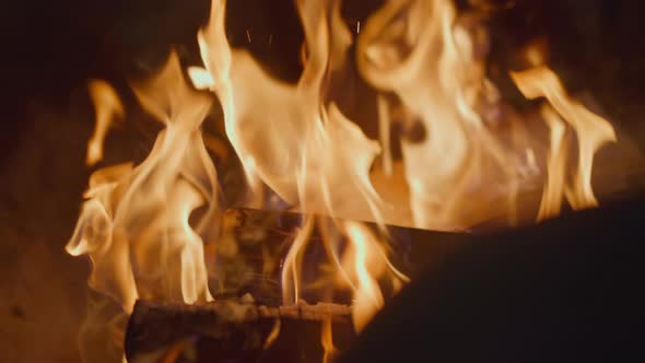 Firewood and Charcoal Burn in Fireplace at Dark Night