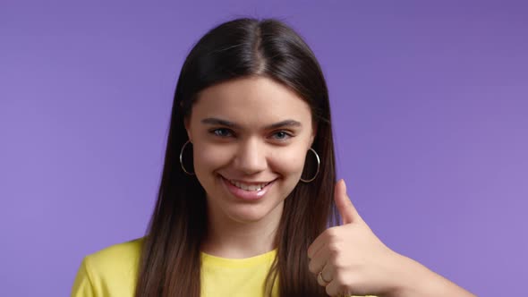 Closeup Woman Showing Thumb Up Sign on Violet Background