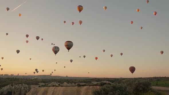 Aerial drone shot of hot air balloons soaring in the sky. Sunny morning in Cappadocia,