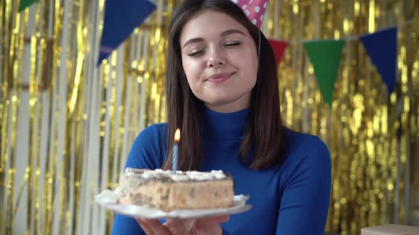 Closeup of a Millennial with a Cake in His Hands Celebrating an Anniversary Makes a Wish Blows Out a