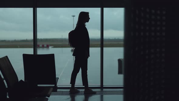 Silhouettes of a Young Woman at the Airport