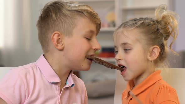 Boy and Girl Eating Chocolate Bar, Having Fun, Unhealthy Snack, High Sugar Level