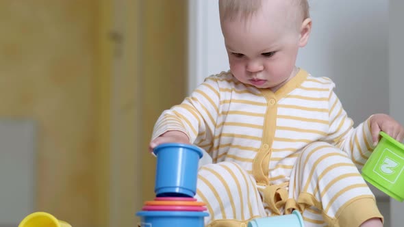 Little Baby Playing with Educational Colorful Toys at Home Sitting on Floor