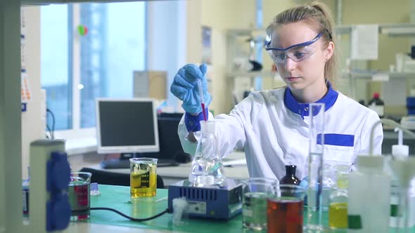 Woman Chemist Studying Mixing Stirring Spinning Liquid in Flask Spbd