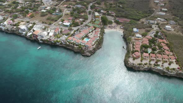 Aerial orbit over the small beach hidden in the rocky shore of Curacao