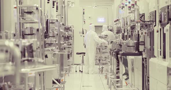 Workers in clean suits in a Semiconductor manufacturing facility