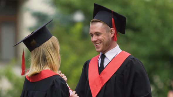 Shy Man Talking to Female Friend at Graduation Ceremony, Achievement, Success