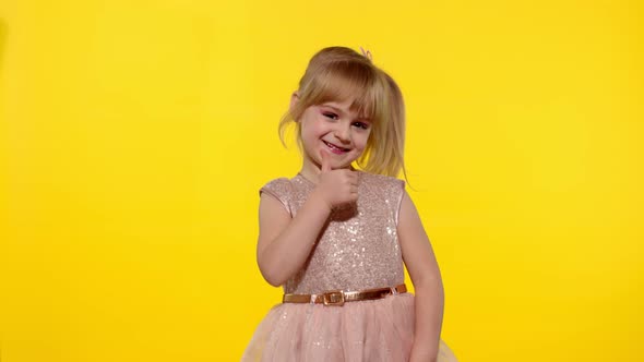 Hello or Bye. Little Smiling Blonde Child Kid Girl Waving Greeting with Hand on Yellow Background