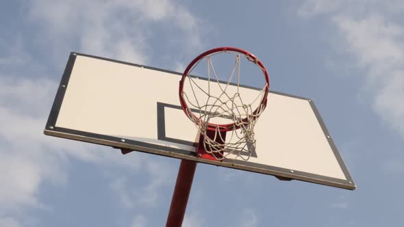 Under basketball hoop with backboard slow motion video