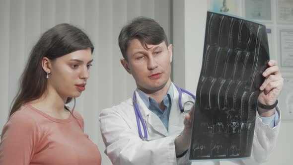 Male Doctor Explaining MRI Survey Results to His Female Patient