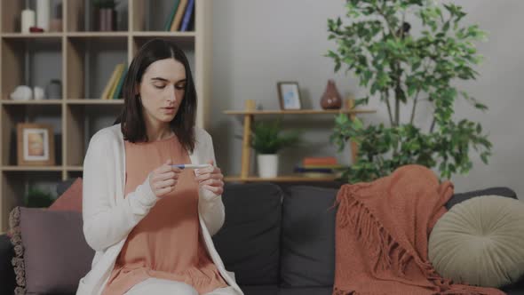 Worried Woman Looking at Results of Pregnancy Test at Home