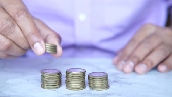 Man's Hand Putting Stack of Coins