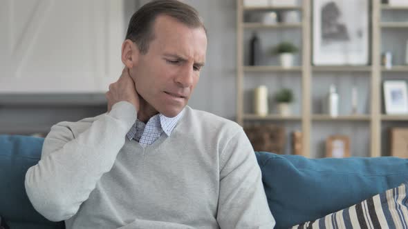 Middle Aged Man Trying to Relaxing Neck Pain at Home