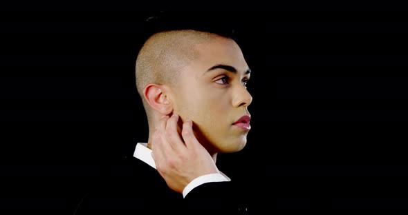 Androgynous man posing against black background