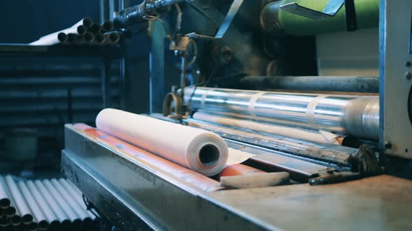 Factory Worker Operating a Paper Roll Making Machine