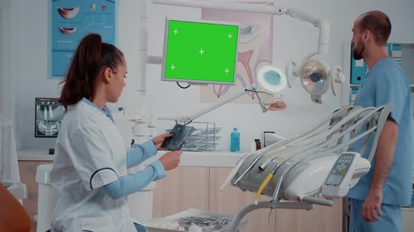 Stomatologist Watching Monitor with Horizontal Green Screen