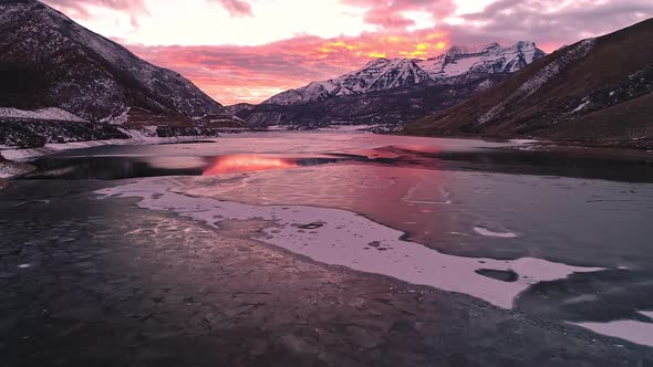 Flying over colorful mountain winter landscape over lake