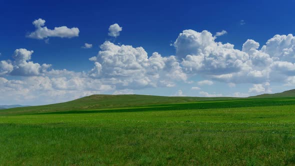 Green Hill with Grass Under Cloudy Sky, Timelapse