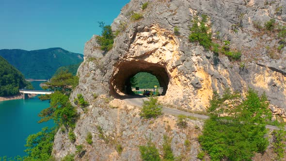 Tourists Stand in the Tunnel at Piva Lake in National Park Dormitor of Montenegro at Summer