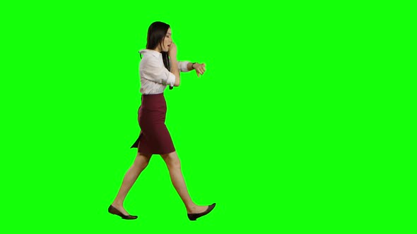 Asian Girl Is Running and Talking on the Phone. Green Screen