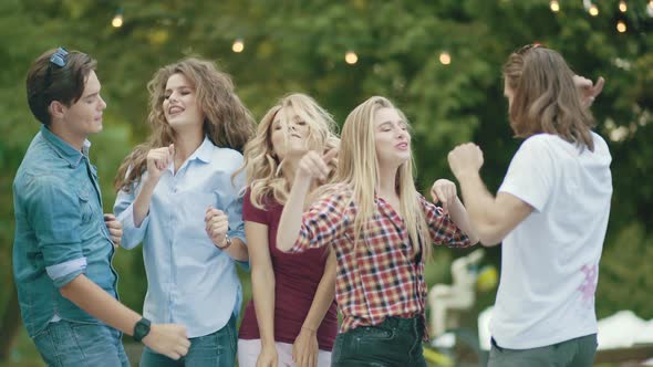 Happy Friends Dancing, Having Fun And Enjoying Party Outdoors.