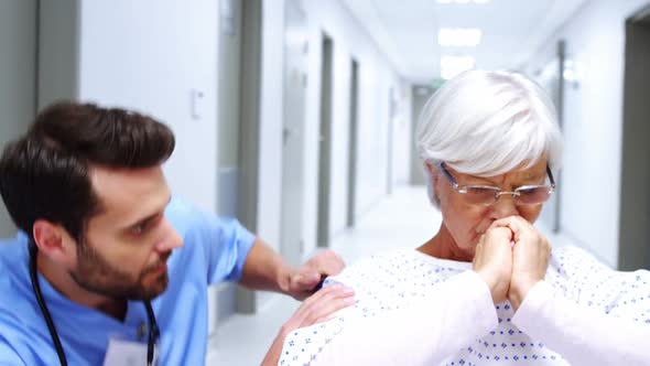 Nurse consoling stressed female senior patient