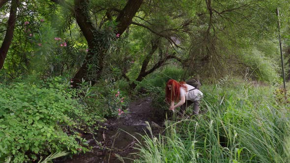 Woman Washing Her Hand From a Flowing Stream