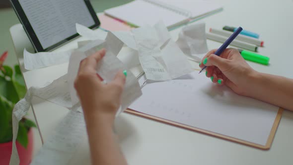 Woman Examining Expenses Bills and Writing on Paper Sitting at Table at Home