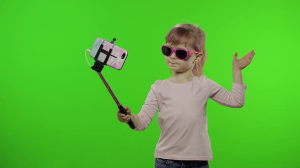 Girl Child Makes Selfie, Blogging on Mobile Phone Using Selfie Stick. Chroma Key