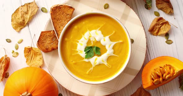 Creamy Pumpkin Soup in Bowl with Herb