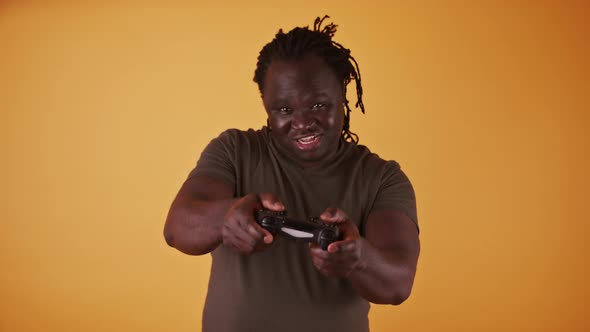 African Man with Game Controler Isolated on Orange Background