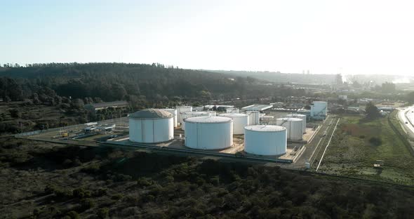 Aerial orbit of white oil tanker containers at sunset