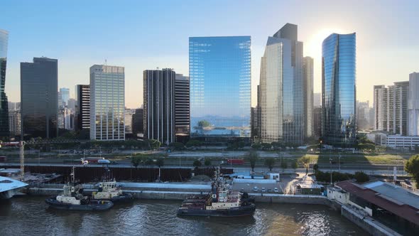 Aerial dolly in of boats in Puerto Madero docks with high-rise skyscrapers at golden hour, Buenos Ai