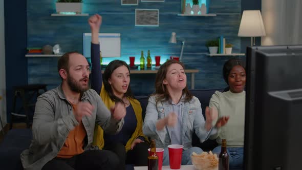 Mixed Race Friends Relaxing on Couch While Watching Football Game