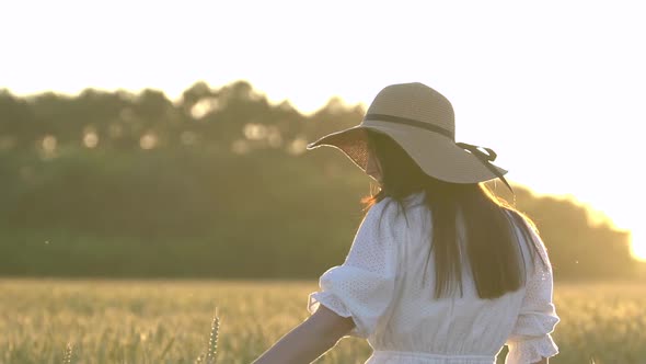 Young Girl Walking in Slow Motion Through a Wheat Field