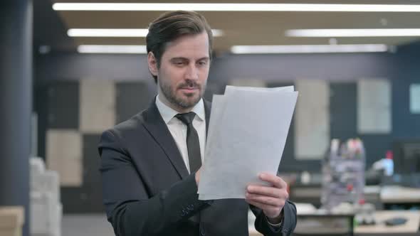 Businessman Reading Documents in Office