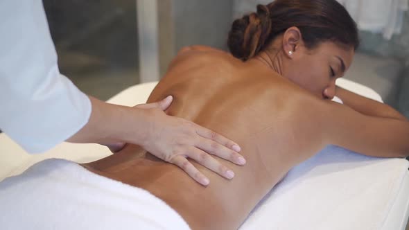 Attractive Dark Hair Woman Is Horizontal Lying on Massage Table and Getting Medical Treatment