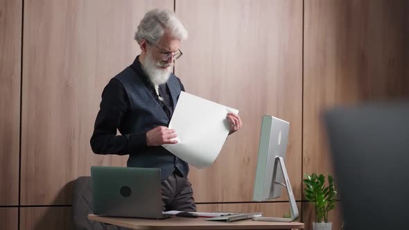 Adult Grayhaired Architect Checks Drawings of Objects Thoughtful University Lecturer Checks